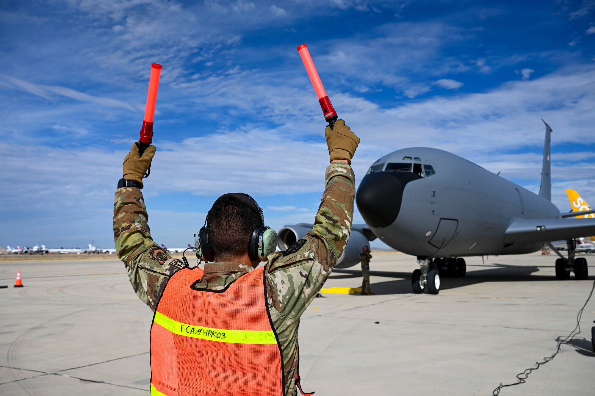 An Airman marshals a jet.