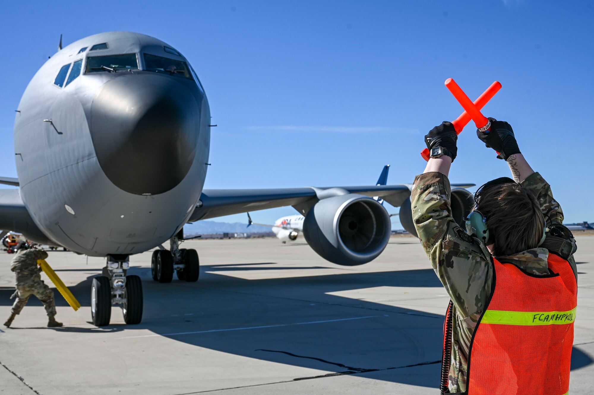 An Airman marshals a jet into place.