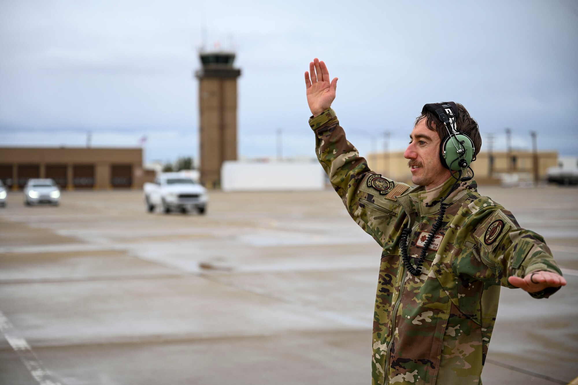 An Air Force officer marshals a jet.