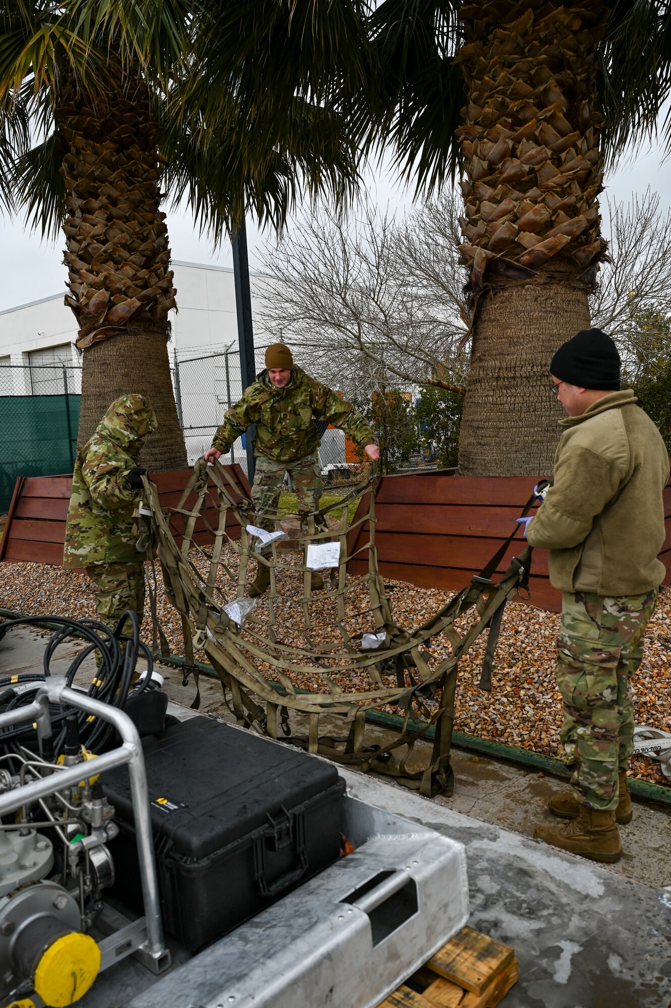Airmen spread out a cargo net.