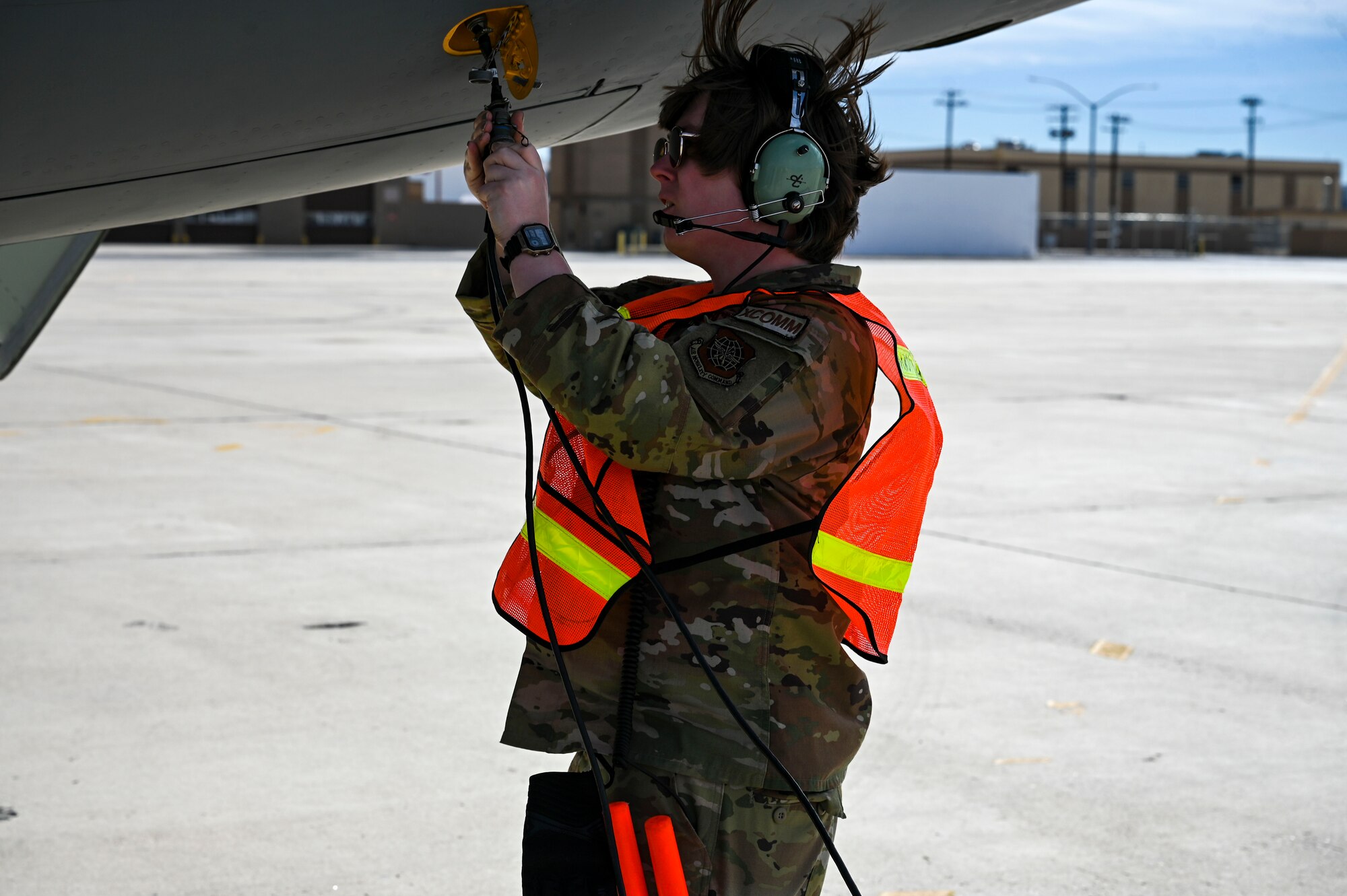 An Airman connects a cable to a jet.