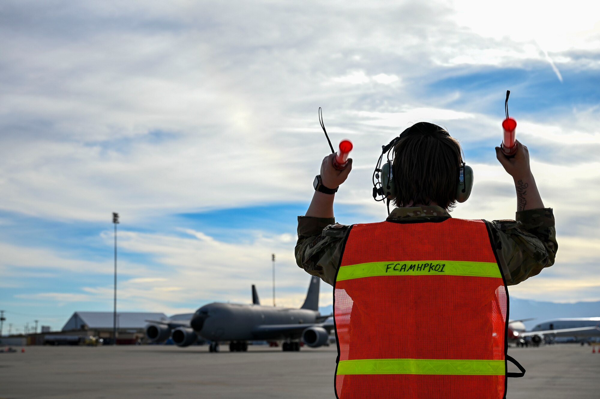 An Airman marshals a jet.