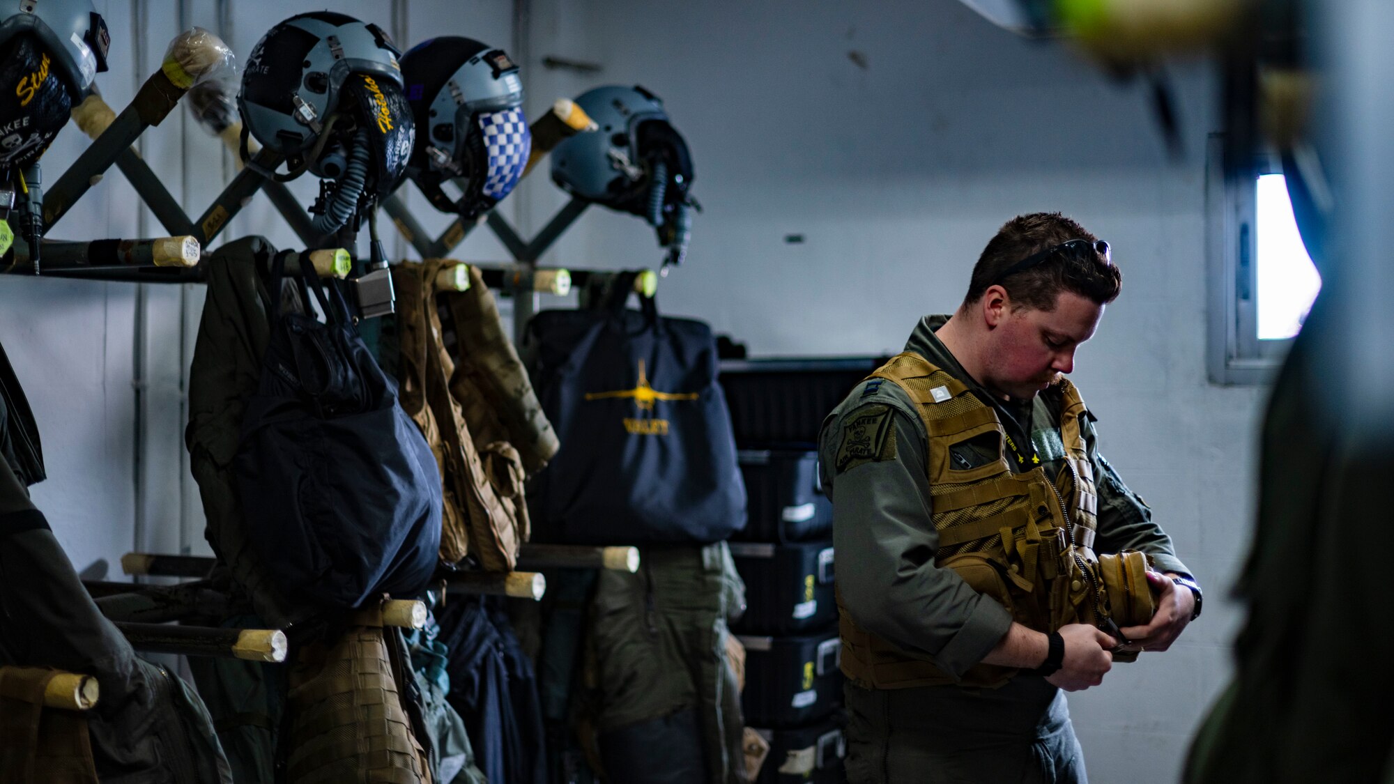 An F-16 Fighting Falcon pilot, dons flight gear before leading U.S. Air Force integration for an amphibious assault exercise