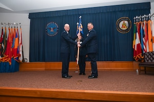 Col. William Gutermuth, 433rd Airlift Wing commander, presents the guidon to Col. James Bershinsky, 433rd Medical Group commander, during the 433rd MDG assumption of command ceremony at Joint Base San Antonio-Lackland, Texas, March 3, 2024.