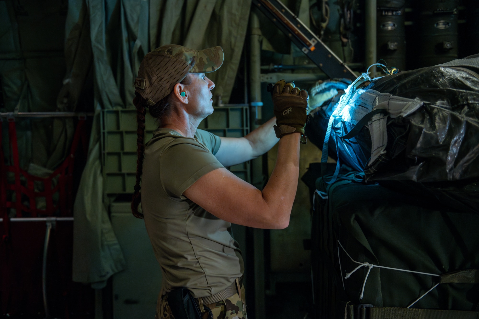 A loadmaster checks the rigging equipment on a parachute attached to a humanitarian aid pallet destined for an airdrop over Gaza.