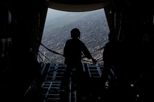 A loadmaster stands on the ramp of a HC-130J Combat King II after airdropping humanitarian aid over Gaza.