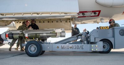 Sailors load a HAAWC weapon system on a P-8A Poseidon maritime patrol aircraft on the VP-30 flight line.