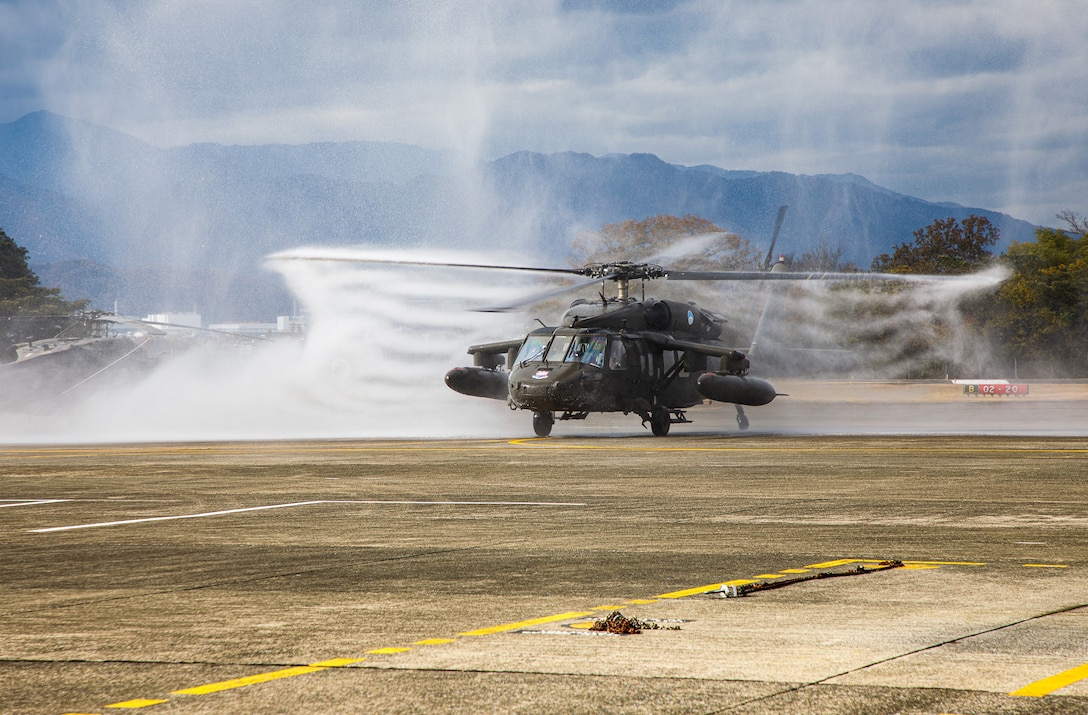 A UH-60 Black Hawk helicopter flown by Chief Warrant Officer 4 Rick Dean, assigned to U.S. Army Aviation Battalion–Japan, is sprayed with water after Dean's final flight at Camp Zama's Kastner Airfield in Japan, Dec. 1, 2023. Dean served 26 years in the Army, much of them as a helicopter pilot. (Photo Credit: Esther Dacanay, U.S. Army Japan Public Affairs)