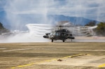 A UH-60 Black Hawk helicopter flown by Chief Warrant Officer 4 Rick Dean, assigned to U.S. Army Aviation Battalion–Japan, is sprayed with water after Dean's final flight at Camp Zama's Kastner Airfield in Japan, Dec. 1, 2023. Dean served 26 years in the Army, much of them as a helicopter pilot. (Photo Credit: Esther Dacanay, U.S. Army Japan Public Affairs)