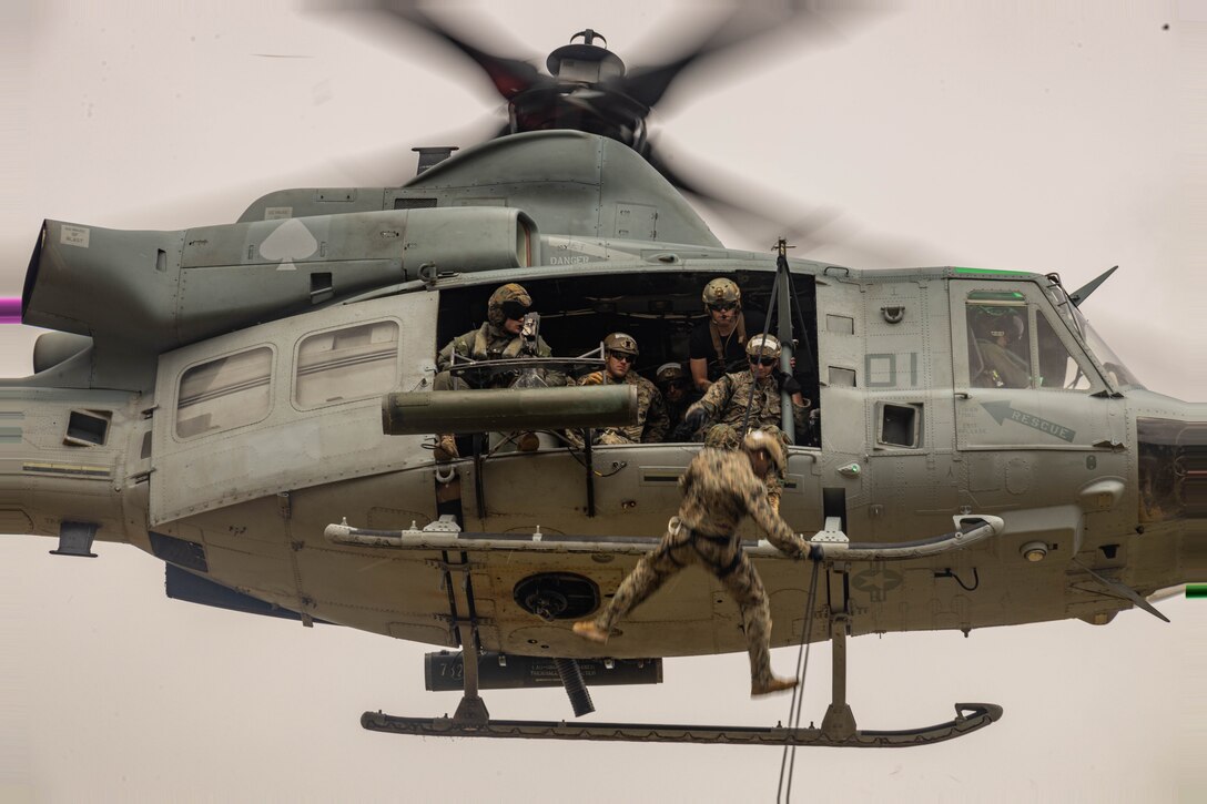U.S. Marines with 1st Reconnaissance Battalion, 1st Marine Division, 4th Reconnaissance Battalion, 4th Marine Division, and 1st Air Naval Gunfire Liaison Company, I Marine Expeditionary Force Information Group, rappel out of a UH-1Y Venom during a helicopter rope suspension techniques course hosted by Expeditionary Operations Training Group, I MEF, at Marine Corps Base Camp Pendleton, California, June 13, 2023. The helicopter rope suspension techniques course creates HRST masters which are capable of supporting fast rope, rappel, and special patrol insertion/extraction operations from any U.S. Marine Corps helicopter and tiltrotor aircraft as a means to insert and extract ground forces into or from rough terrain and urban areas. (U.S. Marine Corps photo by Cpl. Dean Gurule)