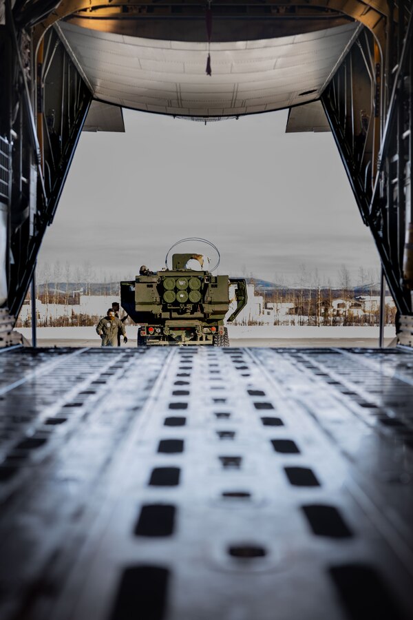 U.S. Marines with Fox Battery, 2nd Battalion, 14th Marine Regiment, 4th Marine Division, Marine Forces Reserve and Marine Aerial Refueler Transport Squadron (VMGR) 234, Marine Aircraft Group 41, 4th Marine Aircraft Wing, Marine Forces Reserve onload a M142 High Mobility Artillery Rocket System (HIMARS) onto a C-130J Hercules during a HIMARS Rapid Infiltration, also known as a HIRAIN, during exercise Arctic Edge 2024 at Eielson Air Force, Alaska, Feb. 24, 2024. The HIRAIN training demonstrated Marine Forces Reserve’s ability to rapidly deploy the HIMARS to meet and deter any threats in any environment, including harsh arctic environments. Arctic Edge 2024 (AE24) is a U.S. Northern Command-led homeland defense exercise demonstrating the U.S. military’s capabilities in extreme cold weather, joint force readiness, and U.S. military commitment to mutual strategic security interests in the arctic region. (U.S. Marine Corps photo by Lance Cpl. Madisyn Paschal)