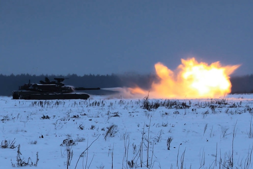 A tank in snow fires a round.