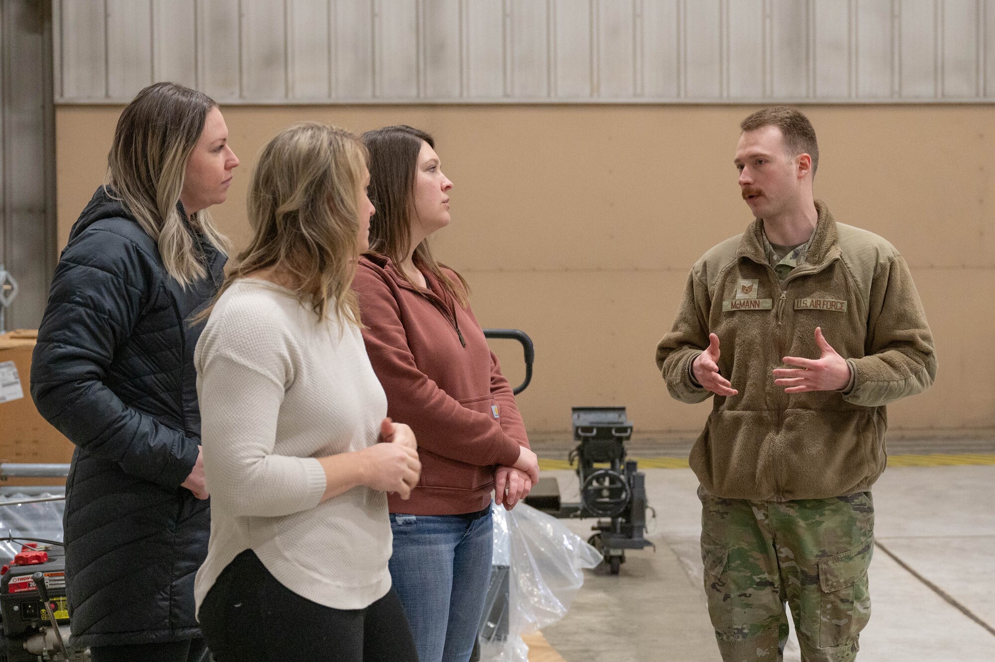 U.S. Air Force Technical Sgt. Brick McMann, 354th Maintenance Squadron fabrication flight briefs 3 354th MXS spouses during the spouses' open house March 1, 2024 at Eielson Air Force Base, Alaska.
