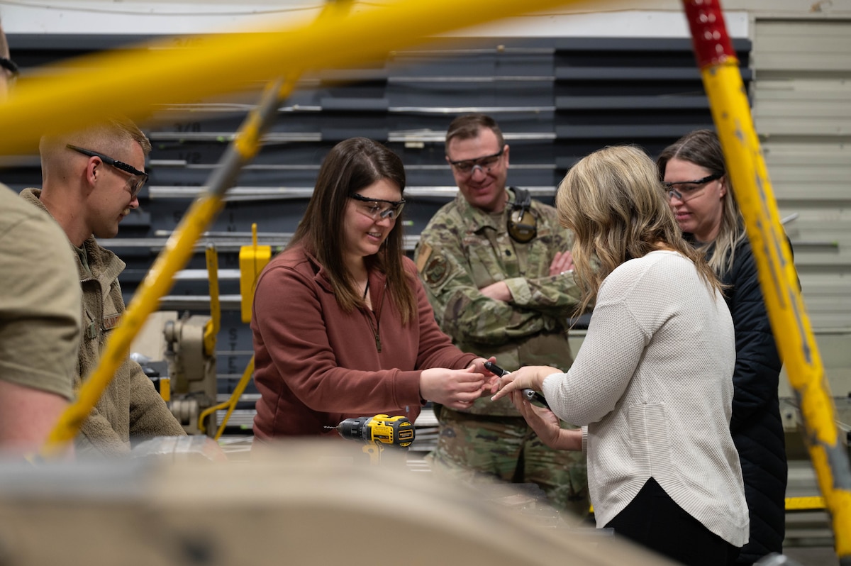 2 Spouses from the 354th Maintenance Squadron participate in a hands-on demonstration with the 354th MXS fabrication flight during the spouses' open house March 1, 2024,