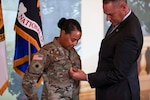 U.S. Army Brig. Gen. Robin Hoeflein, vice director of the Operations Directorate at the National Guard Bureau, looks on as her husband, Ray, affixes her rank to her uniform during a ceremony at Joint Base Myer-Henderson Hall, Virginia, where she was promoted to her current rank Feb. 29, 2024.