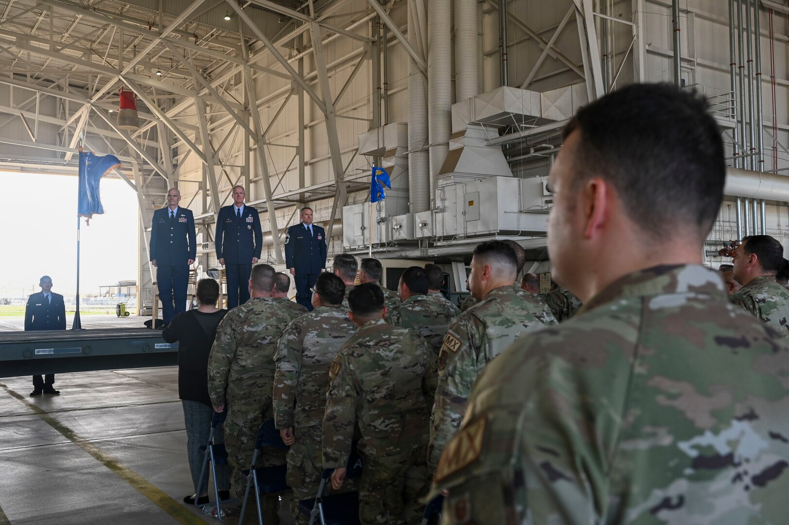 Members of the 433rd Airlift Wing stand at attention during the playing of the U.S. Air Force song during an assumption of command ceremony at Joint Base San Antonio-Lackland, Texas, March 2, 2024