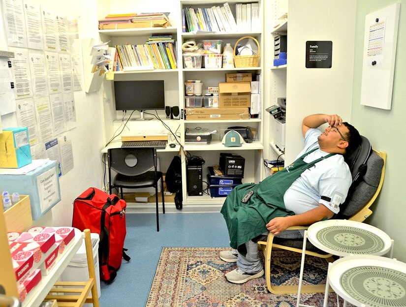 A man sits in a chair in a break room.