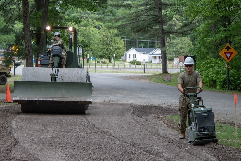 Two service members complete projects at a park.