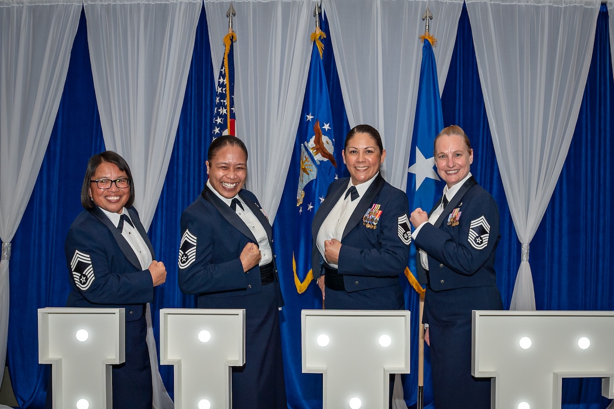Chief Master Sgt. Louann Cornel, Chief Master Sgt. Mae Estoy, Chief Master Sgt. Heather Craig, and Chief Master Sgt. Gale Mears-Paulson flex to show off their new chief stripes.