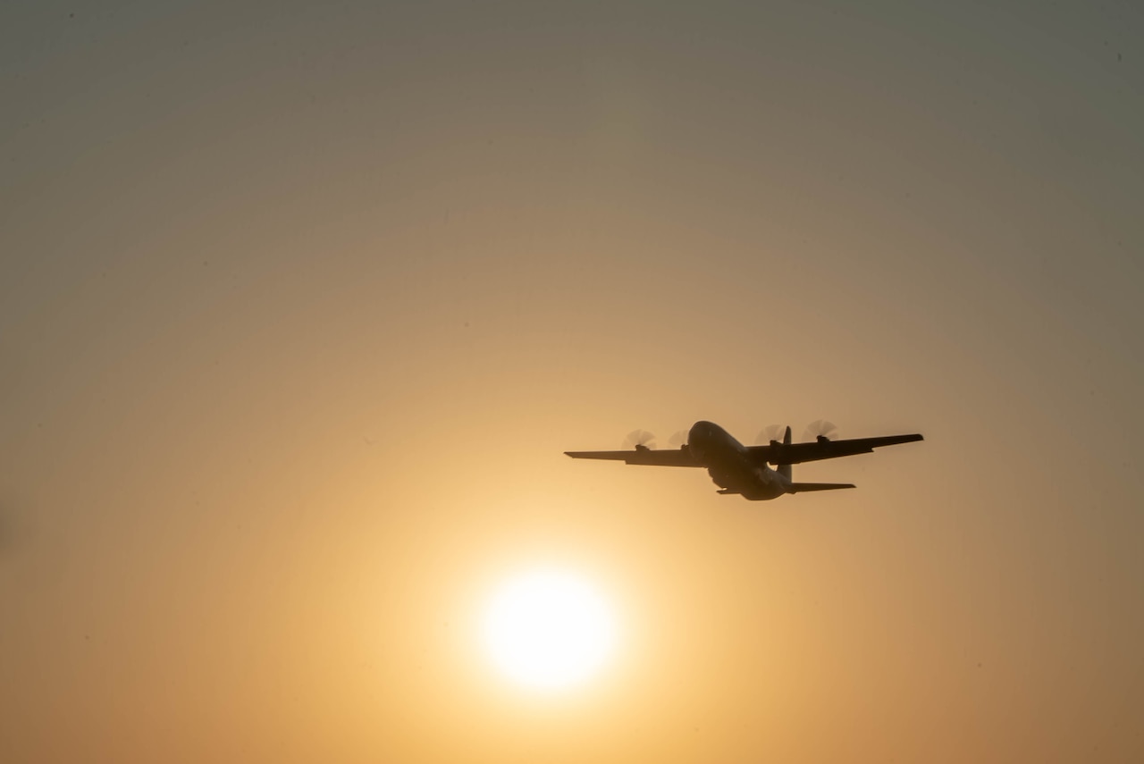 An aircraft flies in a hazy sky.