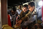 U.S. Air Force Tech. Sgt. Krista McGraw, 18th Aeromedical Evacuation Squadron noncommissioned officer in charge of mission scheduling, showcases a medical supply kit to Bangladesh Air Force medics during an AE demonstration in support of Cope South 2024, Feb. 27, 2024, near BAF Bangabandhu Cantonment, Bangladesh. CS24, a Pacific Air Forces-sponsored bilateral tactical airlift exercise, provides airlift training for U.S. and Bangladeshi aircrews in aircraft generation and recovery, low-level navigation, tactical airdrop, and air-land missions. (U.S. Air Force photo by Staff Sgt. Tristan Truesdell)