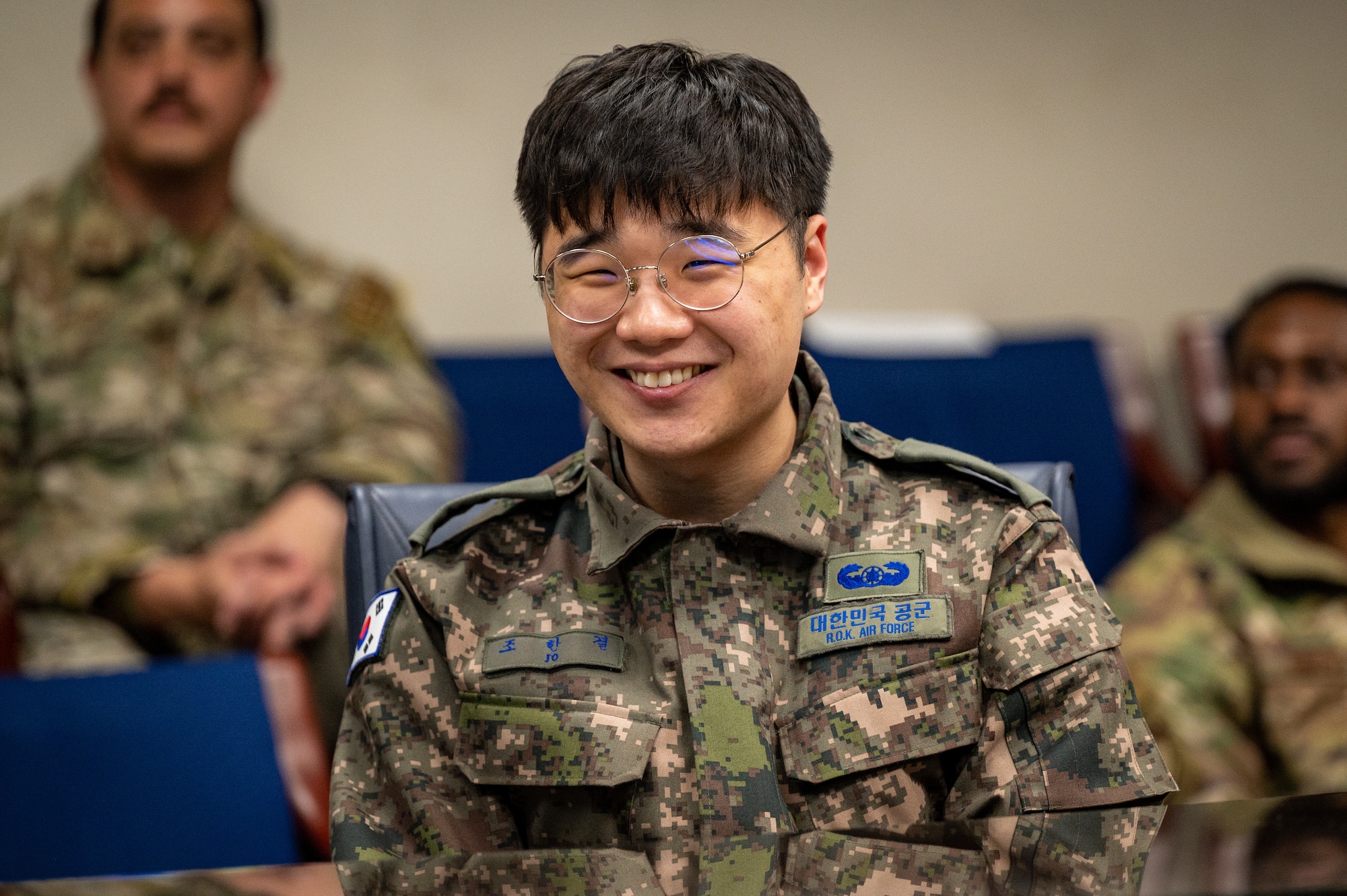 Republic of Korea Air Force Tech. Sgt. Jo, Han Gyeol, a ROKAF civil engineer, smiles as he listens to a presentation during a Noncommissioned Officer Summit at Osan Air Base, Republic of Korea, Feb. 22, 2024. The summit paired 51st Fighter Wing Airmen with their ROKAF counterparts in similar career fields to foster a mutual understanding of each other's operational tactics in both peacetime and war. (U.S. Air Force photo by Staff Sgt. Thomas Sjoberg)