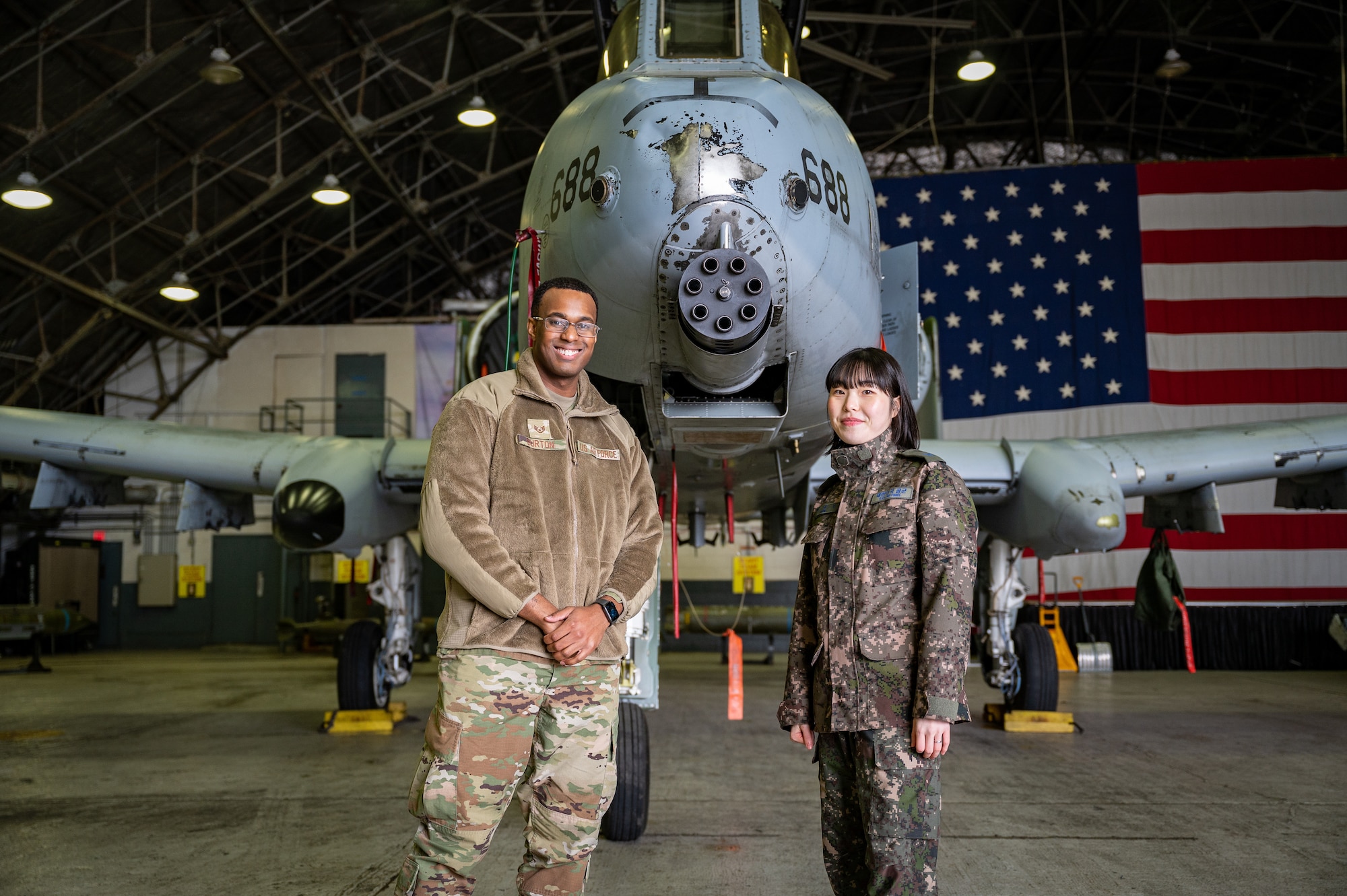 U.S. Air Force Staff Sgt. Darius Burton, left, 51st Communications Squadron client systems technician, and Republic of Korea Air Force Tech. Sgt. Lee, Gyu Bin, ROKAF communications intelligence specialist, pose for a photo in front of an A-10C Thunderbolt II during a Noncommissioned Officer Summit at Osan Air Base, Republic of Korea, Feb. 22, 2024. The summit paired 51st Fighter Wing Airmen with their ROKAF counterparts in similar career fields, aiming to foster mutual understanding of each other's operational tactics and enhance readiness for both peacetime and contingency scenarios. (U.S. Air Force photo by Staff Sgt. Thomas Sjoberg)