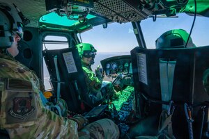 Cockpit photo of two pilots and a flight engineer fly over Utah.