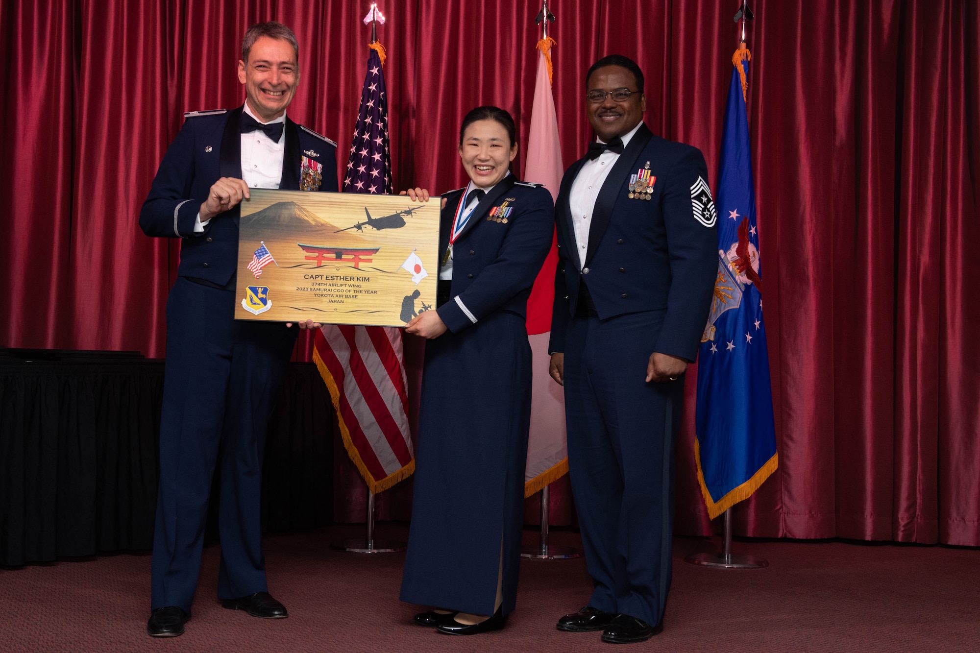 An annual award winner poses for a photo with wing leadership.