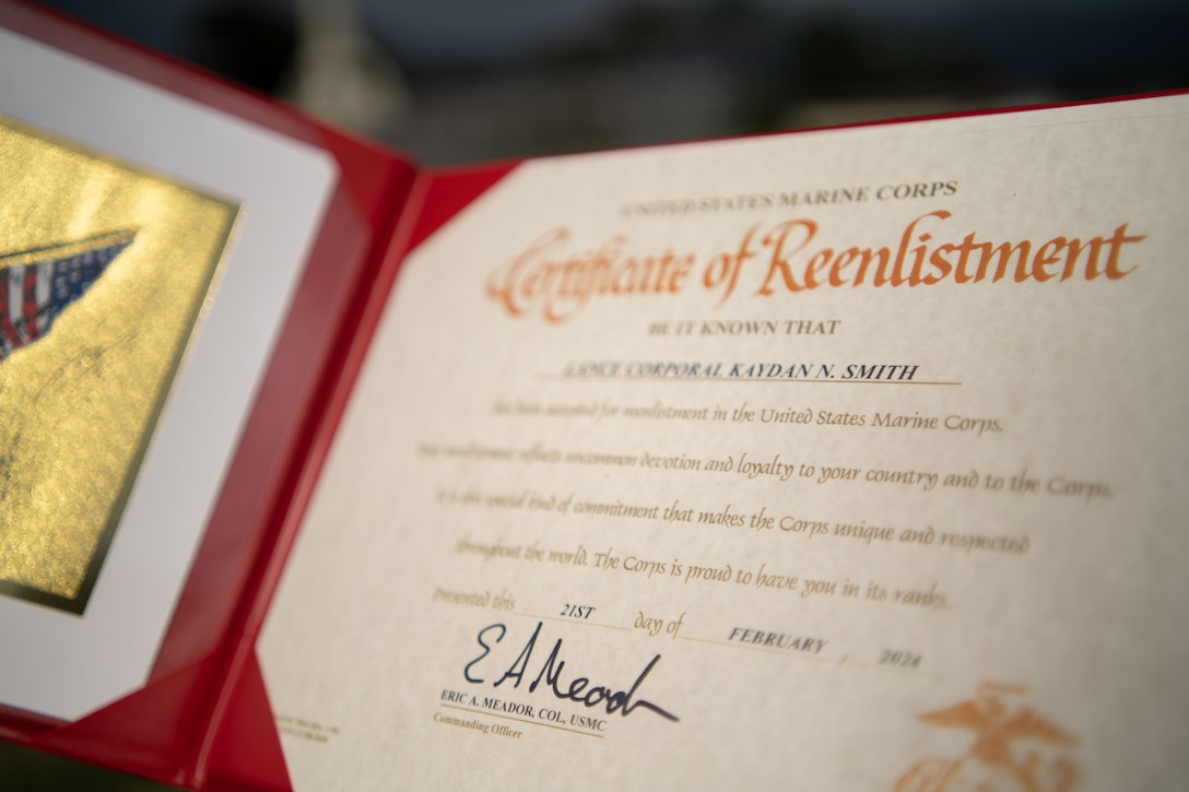 U.S. Marine Corps Lance Cpl. Kaydan N. Smith reenlists during a ceremony on Camp Courtney, Okinawa, Japan, Feb. 21, 2024. Smith said he reenlisted for the Marines around him and for the stability the military provides. “This is my family away from my family,” said Smith. Marines who are eligible for reenlistment demonstrate dedication to duty, professionalism, and leadership ability. Smith, a native of Kansas, is a network administrator with Headquarters Battalion, 3d Marine Division, Okinawa, Japan. (U.S. Marine Corps photo by Staff Sgt. Albert Carls)