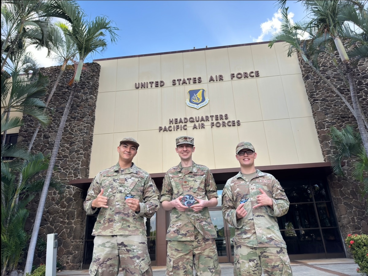 Maryland Air National Guard Tech. Sgt. Andrew Chilcoat (L), a non-kinetic duty technician, Maj. Nate Amsden, a combat plans non-kinetic coordinator, and Staff Sgt. Jeremiah Bishop, a strategy Overseas Contingency Operations planner, pose for a photograph at Pacific Air Forces headquarters during Exercise Keen Edge 2024 at Joint Base Pearl Harbor-Hickam, Hawaii, Feb. 26, 2024.