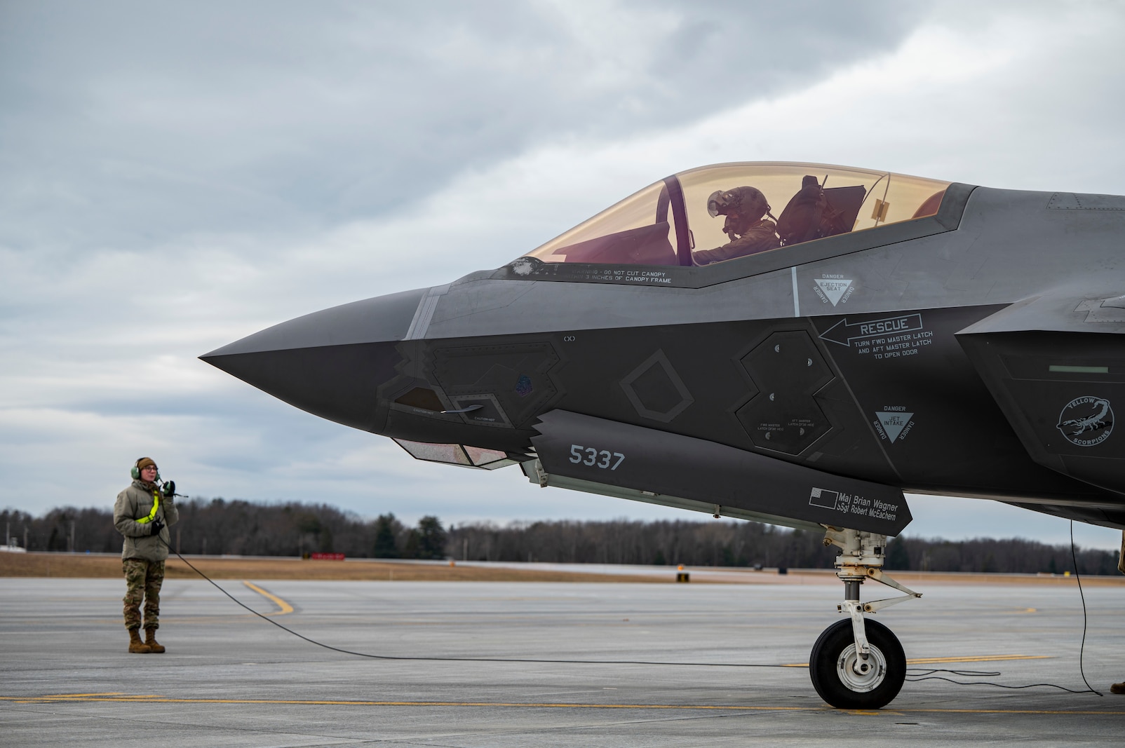 Photo of an F-35A Lightning II crew chief and pilot assigned to the 158th Fighter Wing, Vermont Air National Guard conduct preflight checks on their aircraft at the South Burlington Air National Guard Base, South Burlington, Vermont on March 2, 2024.