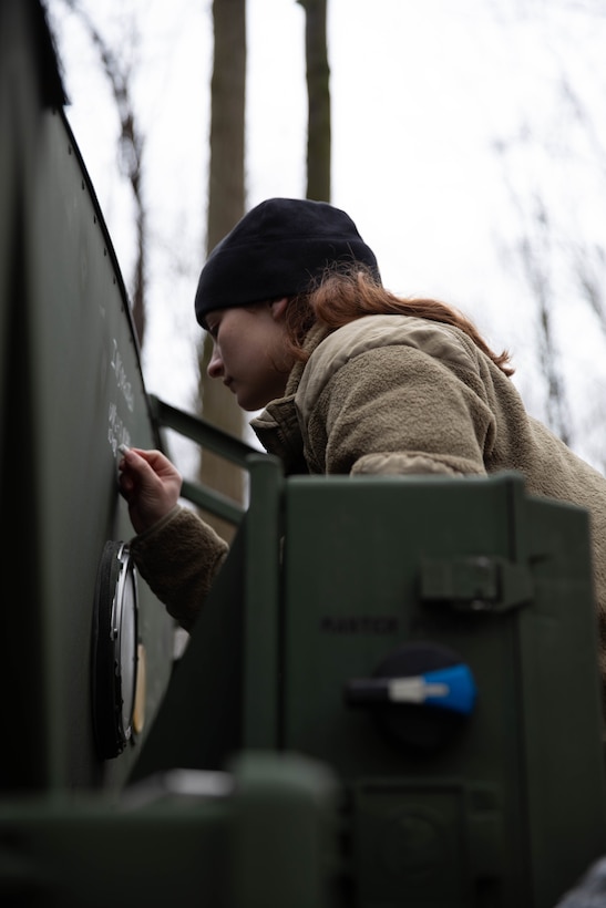 Spc. Ava Halter, a wheeled vehicle mechanic from Company B, 237th Support Battalion, writes on the unit water pod system during the 56th Department of the Army Philip A. Connelly culinary competition at Camp James A. Garfield Joint Military Training Center in Newton Falls, Ohio, March 2, 2024. Halter is a member of the field sanitation team, one of the many positions required to compete in this event. (U.S. Army National Guard photo by Spc. Michael Baumberger, 196th Mobile Public Affairs Detachment)