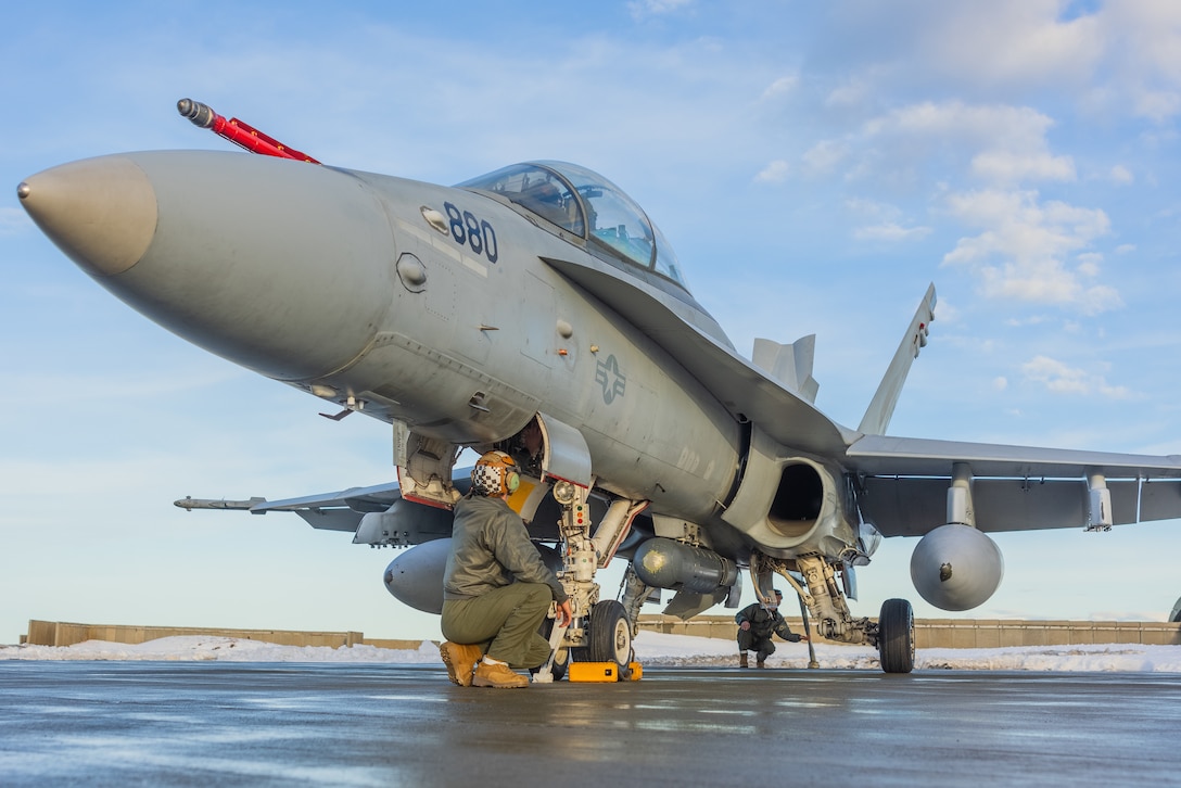 U.S. Marine Corps Lance Cpl. Brent Boren Jr., left, a native of Illinois and a fixed-wing aircraft mechanic with Marine Fighter Attack Squadron (VMFA) 312, 2nd Marine Aircraft Wing, inspects an F/A-18D Hornet in preparation for Exercise Nordic Response 24 at Andenes, Norway, Feb. 23, 2024. Exercise Nordic Response, formerly known as Cold Response, is a NATO training event conducted every two years to promote military competency in arctic environments and to foster interoperability between the U.S. Marine Corps and allied nations. (U.S. Marine Corps photo by Cpl. Christopher Hernandez)