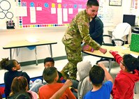 Soldier fist bumps students at library.