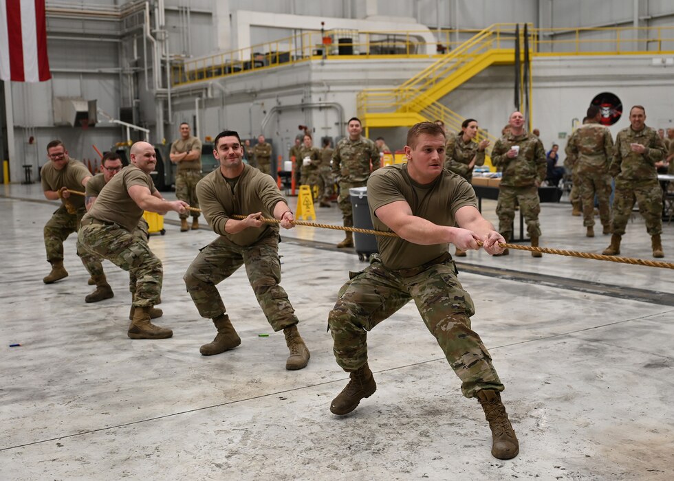 Members of the 445th Aircraft Maintenance Squadron tug for the win in a match of tug-of-war against the 445th Maintenance Squadron (not pictured) during the 445th Maintenance Group Combat Dining Out at Wright-Patterson Air Force Base, Ohio, Feb. 3, 2024. Military and family members laughed and enjoyed an evening of camaraderie and fun as they cheered for others participating in the grog, tug-of-war and nerf gun battles.