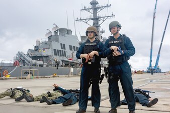 Sailors from USS Higgins (DDG 76) stand guard during a final battle problem drill pierside at White Beach Naval Facility in Okinawa.