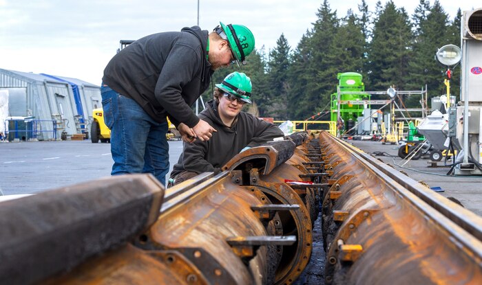 John Farrell and Calvin Sumption, marine machinery mechanics, Shop 38, Marine Machinist, at Puget Sound Naval Shipyard & Intermediate Maintenance Facility in Bremerton, Washington, set cylinders during work to align a catapult aboard USS Nimitz (CVN 68), Jan. 7, 2024. (U.S Navy photo by Wendy Hallmark)