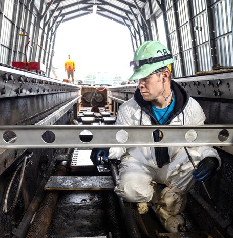 Joshua Fauver, marine machinery mechanic, Shop 38, Marine Machinist, carrier at Puget Sound Naval Shipyard & Intermediate Maintenance Facility in Bremerton, Washington, measures foot pads. (U.S Navy photo by Wendy Hallmark)