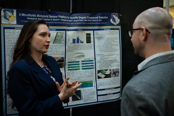 Air Force Research Laboratory, or AFRL, Human Effectiveness Directorate contractor Dr. Elisabeth Steel, left, and Dr. Adam Braunschweig, right, professor of nanoscience and chemistry, City University of New York, discuss research during the poster session at the AFRL Biotech Days Summit Feb. 27, 2024, at Wright-State University in Dayton, Ohio. More than 275 people attended the two-day event, which included presentations highlighting the lab's early to mid-stage technologies, and featured demonstrations and various speakers. (U.S. Air Force photo / Richard Eldridge).