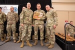 Maj. Gen. Robert Carruthers, left, and Command Sgt. Maj. Jasen Pask , right, award Spc. David Little as the Best Warrior Soldier of the Year at Camp Blanding Joint Training Center, March 3, 2024. Best Warrior 2024 is an annually held competition that tests Florida Army National Guard Soldiers mental and physical endurance as they compete against peers. ( U.S. Army photo by Sgt. N.W. Huertas)