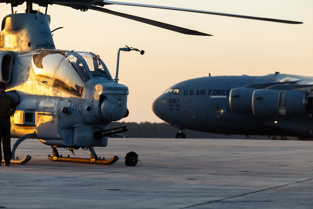 A U.S. Marine Corps AH-1Z Viper assigned to Marine Light Attack Helicopter Squadron-167 (HMLA-167) from Marine Corps Air Station New River sits on the airfield in front of a U.S. Air Force C-17 Globemaster III during Exercise Diavoli Vale, MCAS Cherry Point, North Carolina, Feb 26, 2024. The 621st Contingency Response Group conducted Exercise Diavoli Vale to show its interoperability with other forces as well as its self-sufficient capabilities which allow it to open, operate and/or close any airfield around the globe. (U.S. Marine Corps photos by Lance Cpl. Matthew Williams)