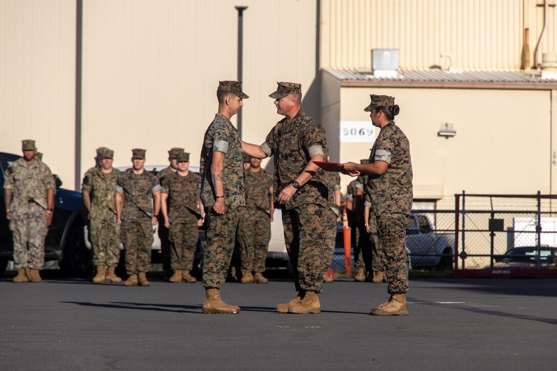 U.S. Marine Corps Lance Cpl. Kayden Cardona, aircraft maintenance support equipment electrician with Marine Aviation Logistics Squadron (MALS) 24, Marine Aircraft Group (MAG) 24, 1st Marine Aircraft Wing (MAW) receives an award from Col. William Heiken, commanding officer of MAG-24, 1st MAW at Marine Corps Air Station Kaneohe Bay, Hawaii, March 1, 2024. Cardona was awarded the Navy and Marine Corps Commendation Medal for lifesaving actions. (U.S. Marine Corps photo by Lance Cpl. Logan Beeney)