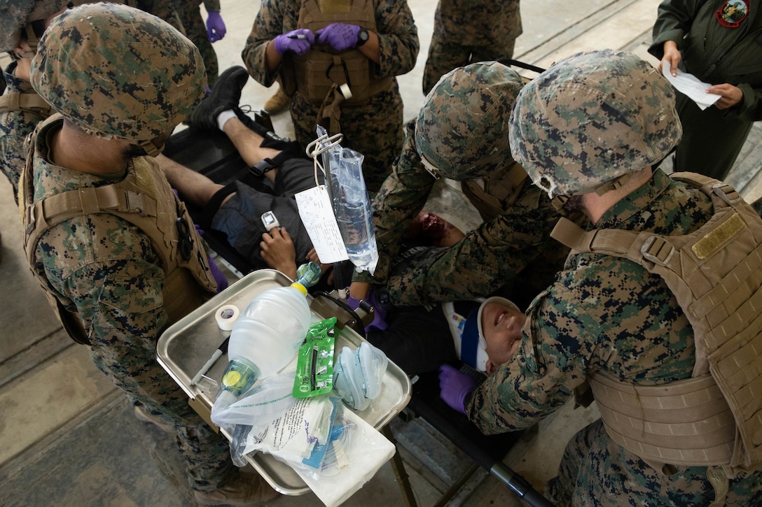 U.S. Sailors with Marine Aircraft Group 24, 1st Marine Aircraft Wing, assess a mock patient’s medical needs during a mass casualty exercise at Marine Corps Training Area Bellows, Hawaii, March 1, 2024. This training familiarized U.S. Marines and Sailors with proper casualty evacuation procedures. (U.S. Marine Corps photo by Lance Cpl. Tania Guerrero)