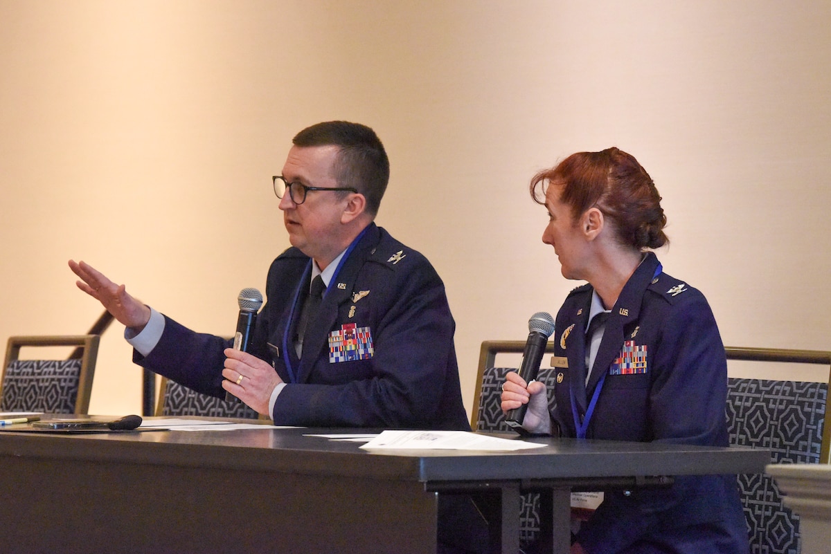 Image of service members speaking at a conference.