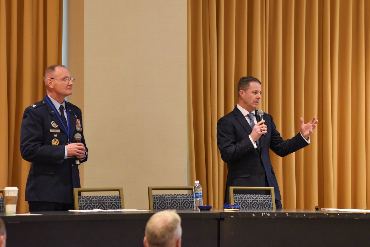 Image of service members speaking at a conference.