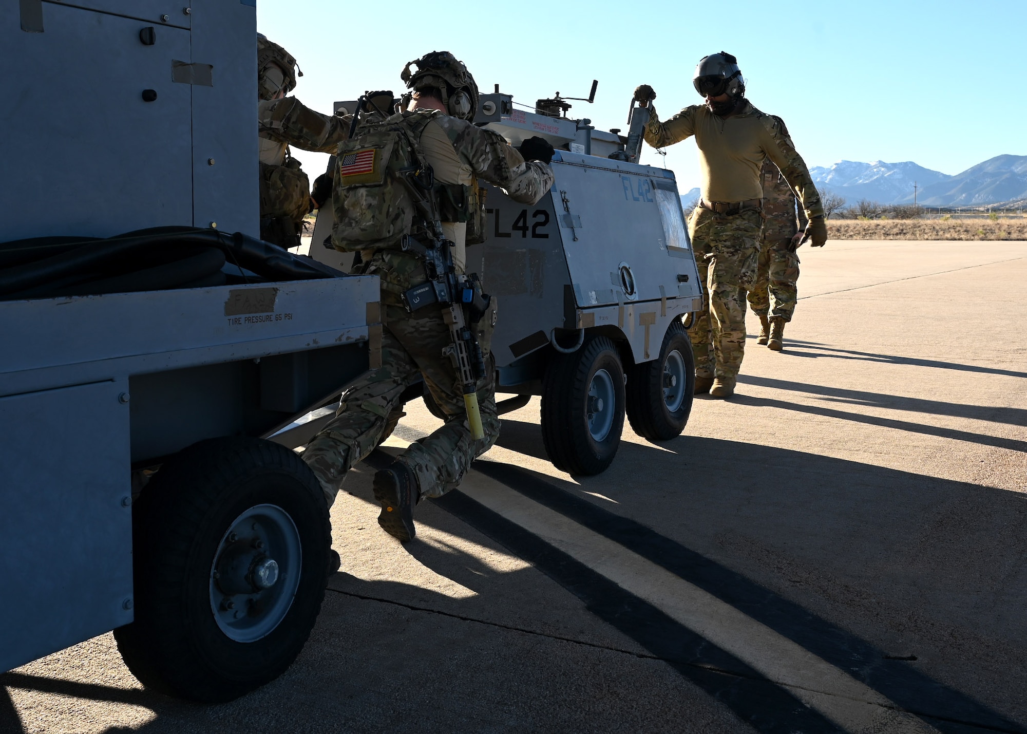 U.S. Airmen assigned to the 48th Rescue Squadron push an aircraft generator and flood lights during Exercise Agile Angel at Fort Huachuca, Ariz., Feb. 20, 2024. Training outside of their particular specialties was deliberately designed to outpace adversary action in the future fight. (U.S. Air Force photo by Staff Sgt. Abbey Rieves)