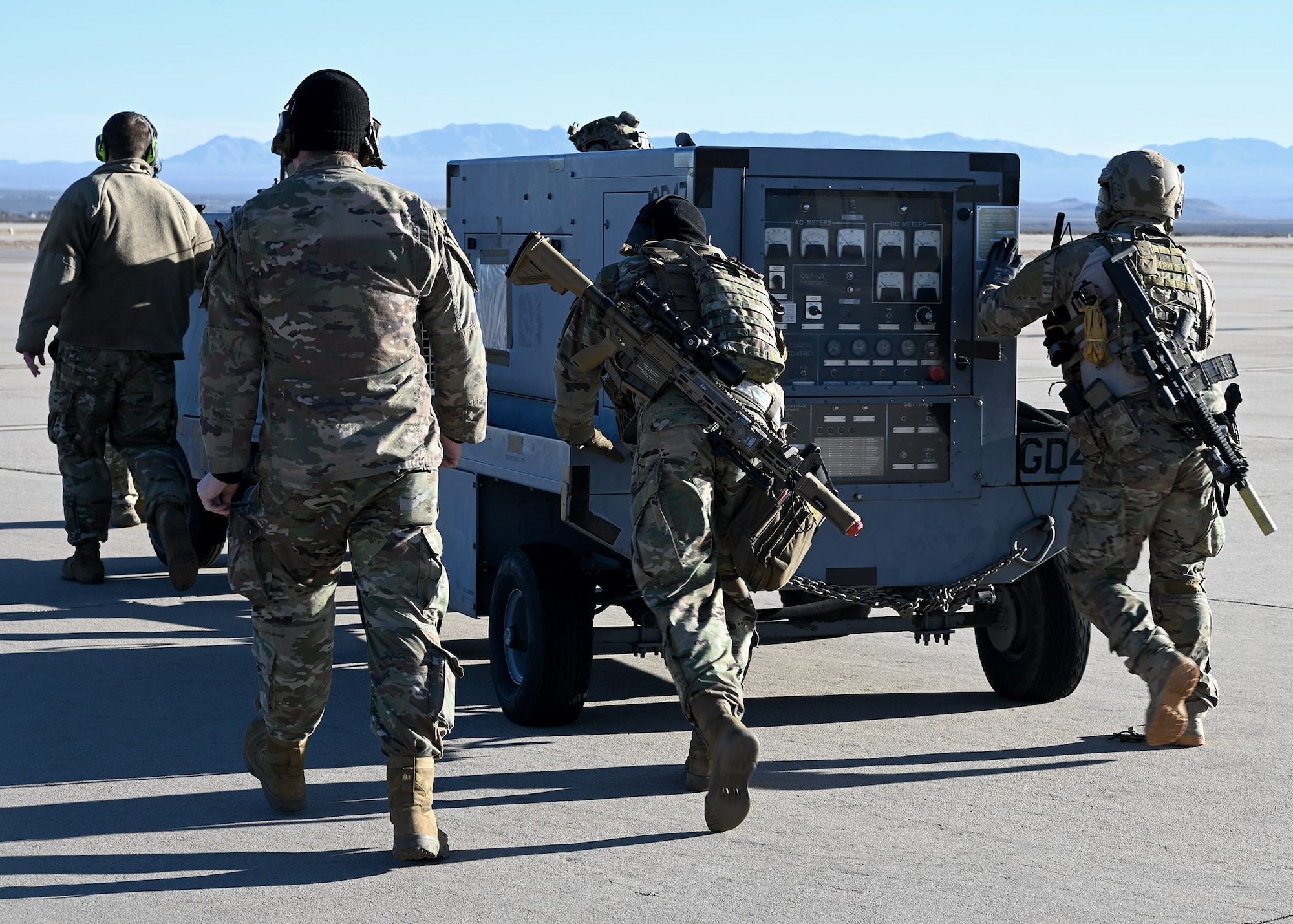 U.S. Airmen assigned to the 48th Rescue Squadron push an aircraft generator and flood lights during Exercise Agile Angel at Fort Huachuca, Ariz., Feb. 20, 2024. Training outside of their particular specialties was deliberately designed to outpace adversary action in the future fight. (U.S. Air Force photo by Staff Sgt. Abbey Rieves)