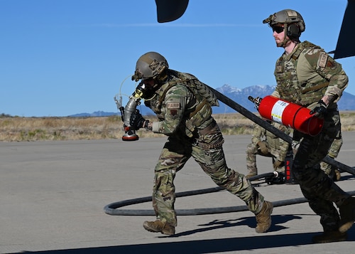 U.S. Air Force Senior Airman Oliver Wendland, right, and Tech. Sgt. Daniel Middaugh, left, 355th Logistics Readiness Squadron forward area refueling point operators, race a fuel hose and fire extinguisher during Exercise Agile Angel at Fort Huachuca, Ariz., Feb. 20, 2024. The fuel hose weighed approximately 70-80 pounds. (U.S. Air Force photo by Staff Sgt. Abbey Rieves)