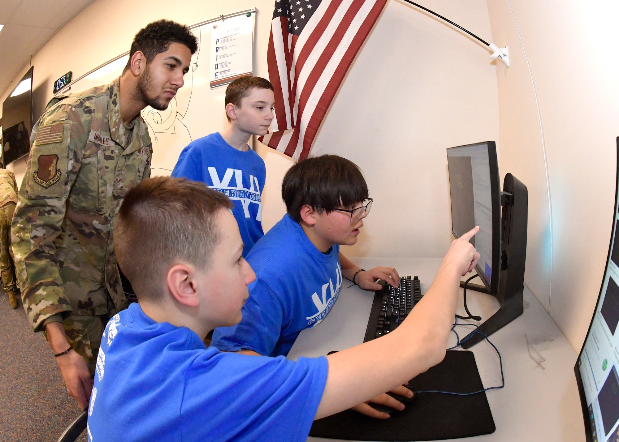 Senior Airman Rafael Morales, 75th Communication and Information Directorate client systems technician, reviews an image with students Feb. 14, 2024, at Quest Academy Charter School in West Haven, Utah. The student team recently competed in the National Youth Cyber Defense Competition, the nation's largest that puts middle and high school students in charge of securing a simulated virtual network. The middle school team placed first in the state of Utah this year, which was in the top 11% nationally of the state finals competition and in the top 15% nationally in the national semi-finals.